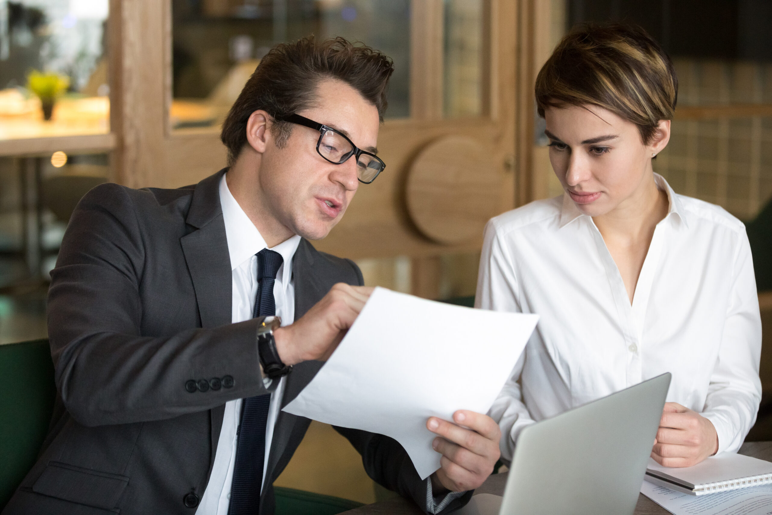 Businessman consulting with female colleague on contract conditi