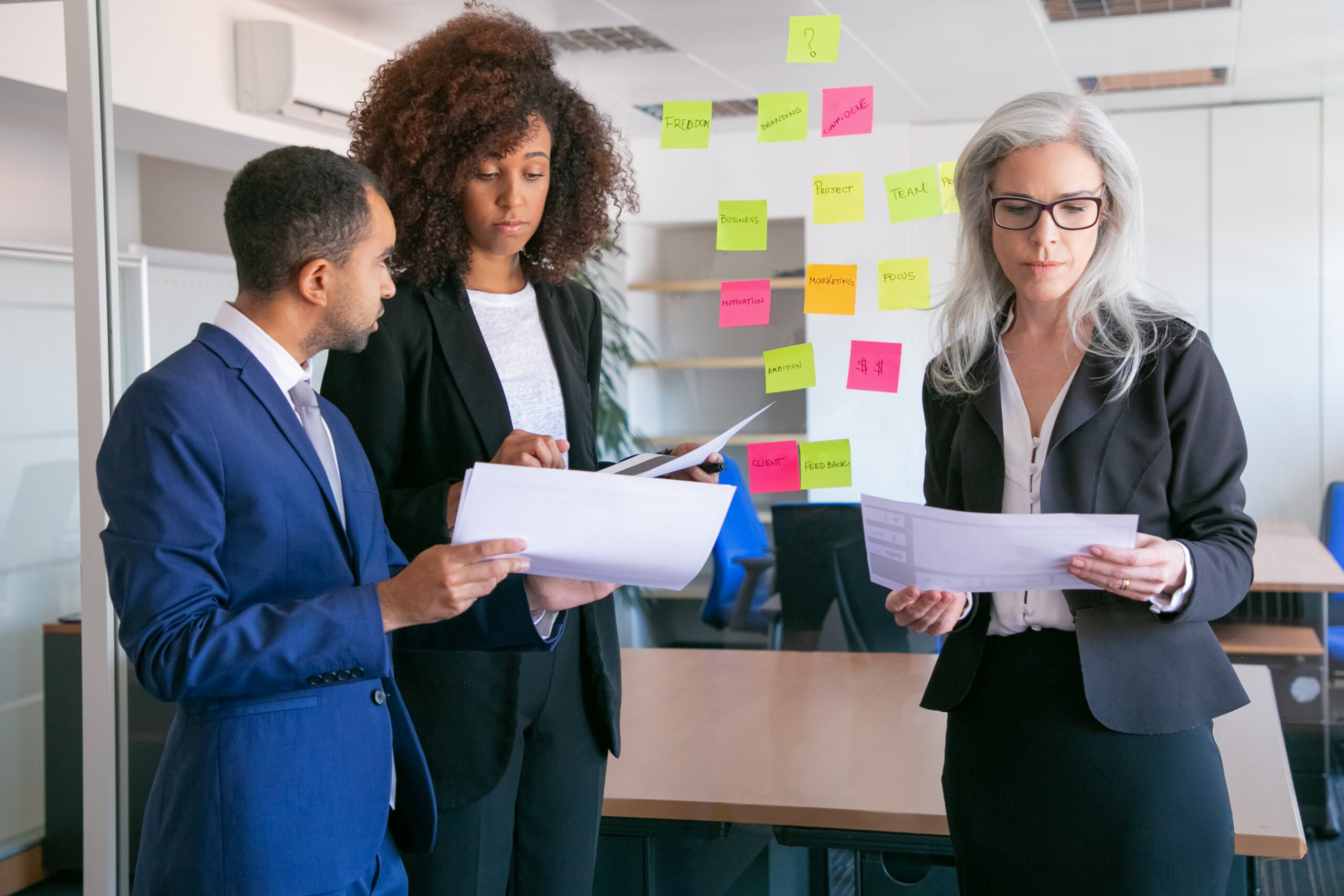 Focused businesspeople reading documents with statistics