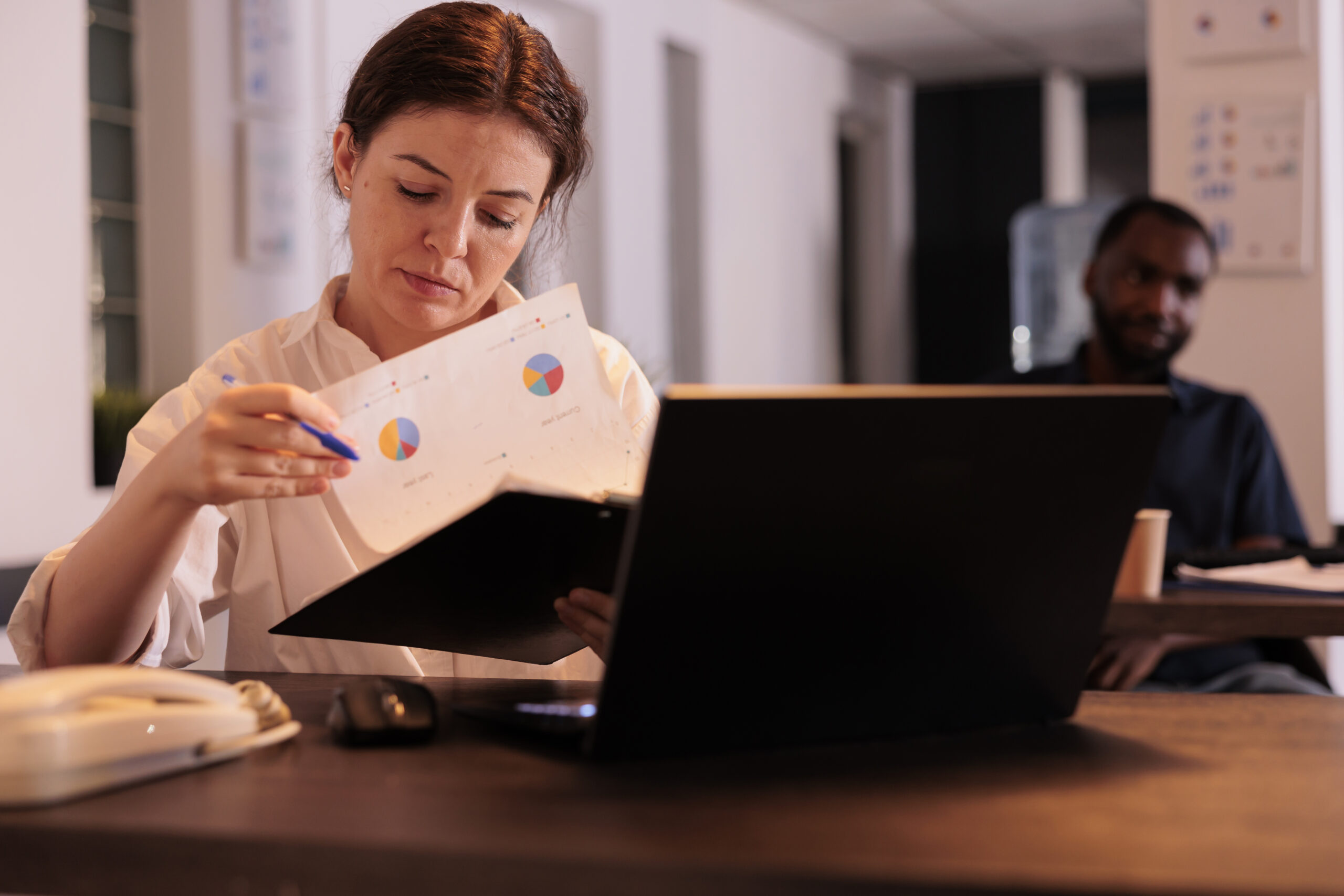 Financial analyst reading company report, analyzing statistics data